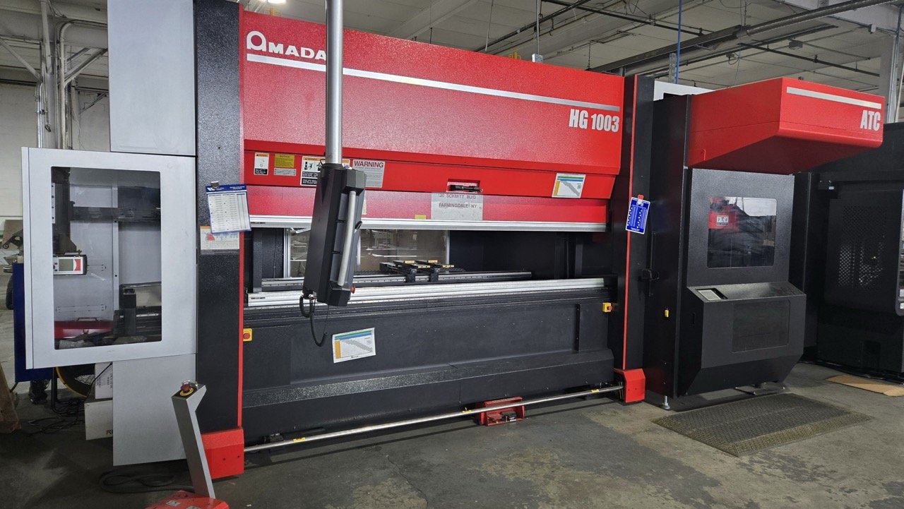 Large industrial press brake machine in workshop.